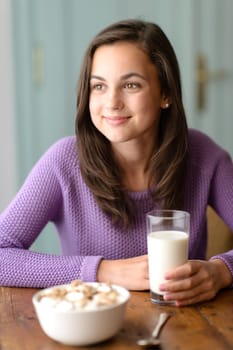 Thinking teenage girl enjoy healthy cereal breakfast looking aside
