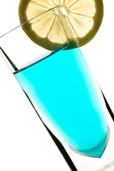 Blue cocktail in glass with yellow lemon