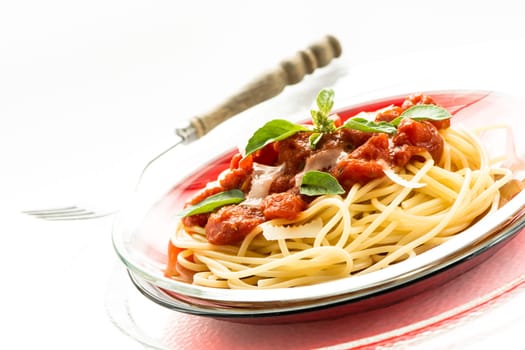 Spaghetti with red tomato sauce and green basil