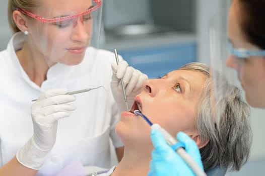 Dental team teeth checkup elderly patient woman open mouth surgery