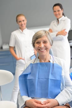 Senior woman patient with professional dentist team at dental surgery