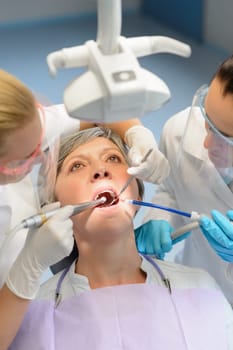Elderly woman patient open mouth dental checkup professional dentist team