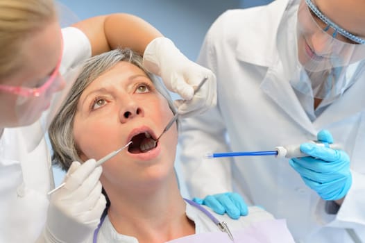 Dental check elderly woman patient professional dentist team open mouth