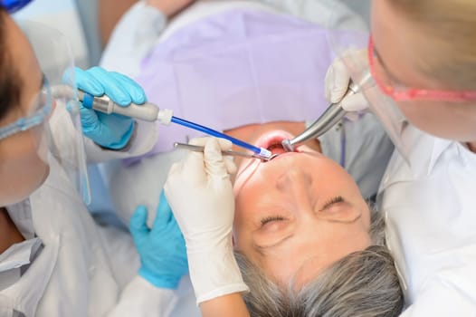 Dental checkup senior patient woman professional dentist team top view