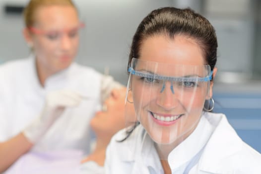 Professional dentist with protective glasses patient woman dental checkup