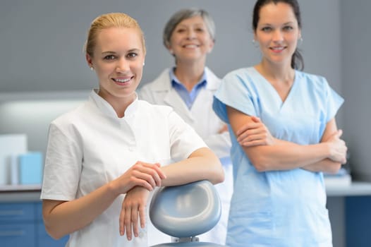 Three professional dentist woman team standing dental surgery  looking camera