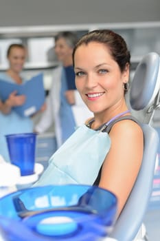 Woman patient sitting chair dental surgery professional dentist team checkup
