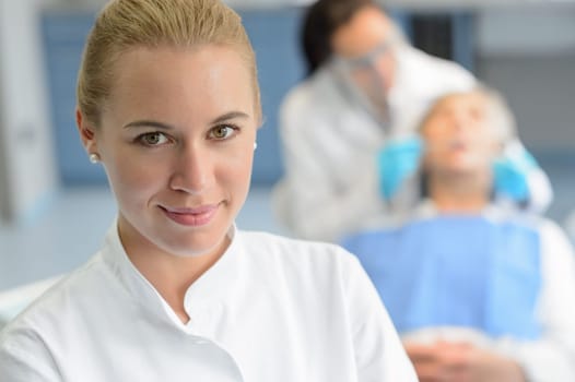Dental assistant closeup looking camera professional dentist checkup patient woman