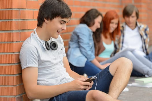 Young student man hanging out with college friends sitting ground