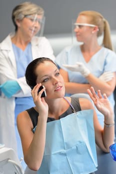 Busy businesswoman patient calling phone at dentist office doctor waiting