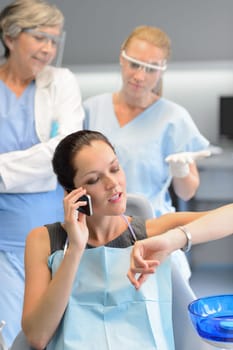 Impatient businesswoman patient on phone at dental clinic dentists waiting
