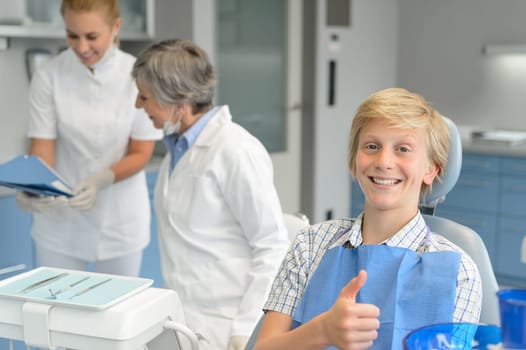 Teenage boy patient teeth checkup at dental surgery dentist woman