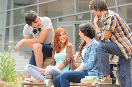 Group of student friends sitting bench outside college hanging out