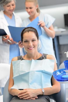 Businesswoman sitting chair dental surgery dentist checkup assistant in background