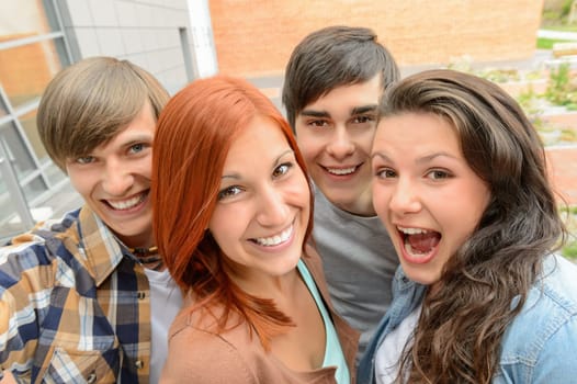 Cheerful teenager friends taking selfie having fun outside campus