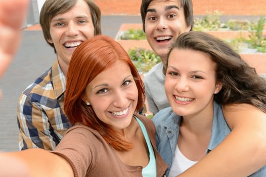 Group of student teenage friends taking selfie laughing at camera