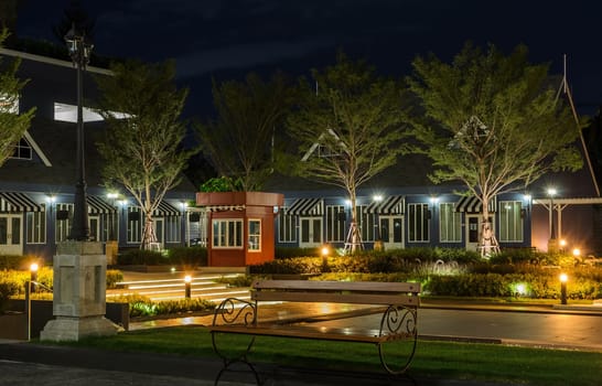 Garden bench in front of Dutch style house at night