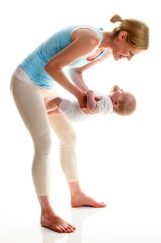 Young mother does back-education gymnastics with her 6-month-old daughter,isolated against a white background. She stands on the ground and holds her child in front of her like a weight.