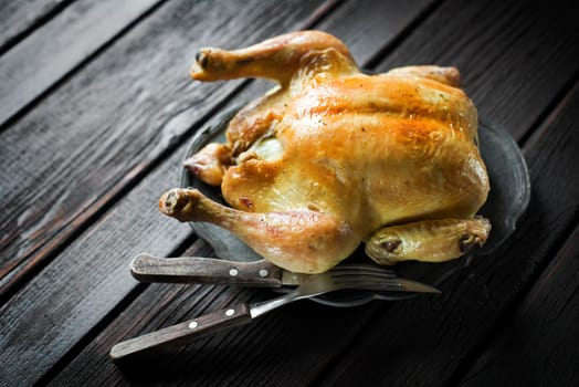 Whole roasted chicken on a wooden table