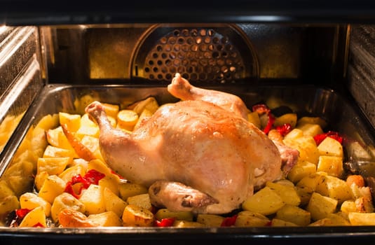 Roast whole chicken with potatoes in the oven