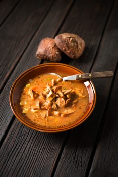 Fresh mushroom soup on wooden background close up