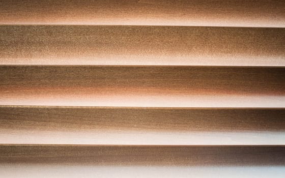 Dim light  through wooden jalousie at a window