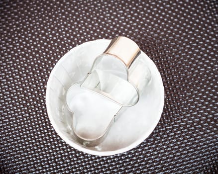 Forms for cookies in paper cup on grunde background