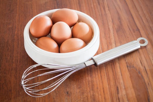 Fresh chicken eggs and hand mixer for beating