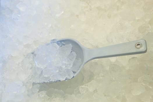 Ice scoop in fresh cool ice background