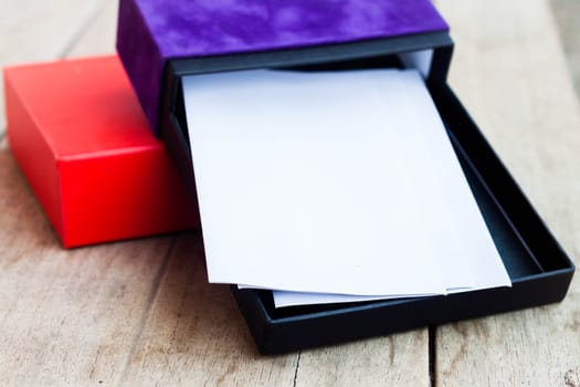 Envelopes in open gift box on wooden table