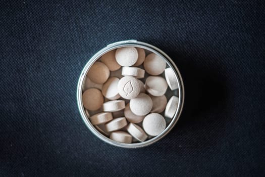 Natural vitamin pills in package on dark background