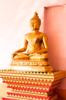 Sitting bronze buddha image statue at side