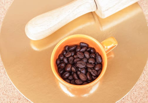 Roasted coffee beans in a cup on the table