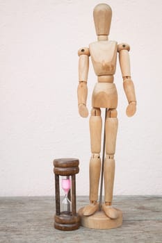 Wood mannequin and hourglass to represent spending time