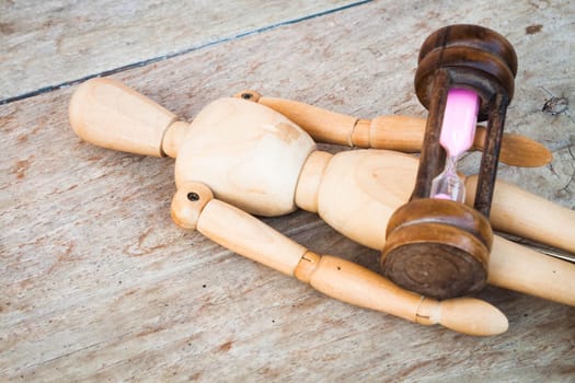 Wood mannequin and hourglass display time relaxing