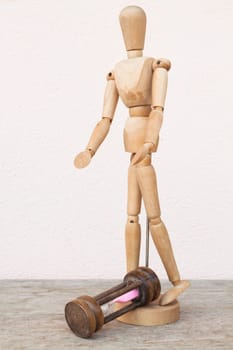 Wood mannequin and hourglass to represent unfortunately time