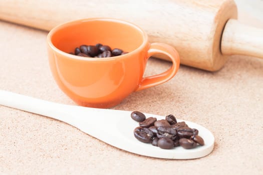 Roast coffee bean in a cup and wood spoon