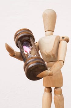Wood mannequin and hourglass to represent time giving