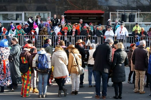 Cologne,Germany – March 02,2014: Colourfully dressed people wearing masks and costumes await the carnival procession on March 2,2014 in Cologne.