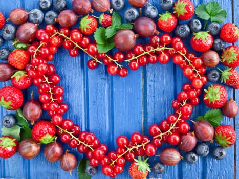 Background with fresh summer berries in heart shape