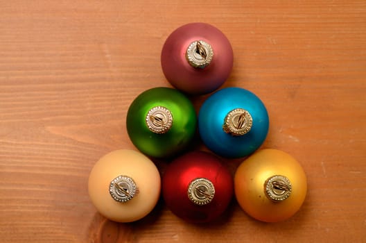 Old used colorful Christmas baubles on a wooden background