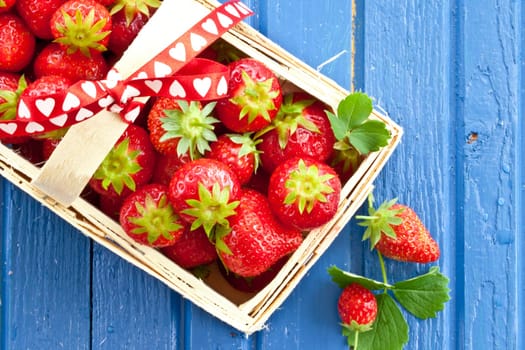Small basket full of fresh red strawberries