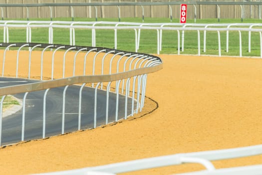 Horse racing tracks section poly synthetic and grass with railing.