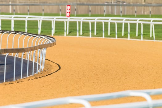Horse racing tracks section poly synthetic and grass with railing.