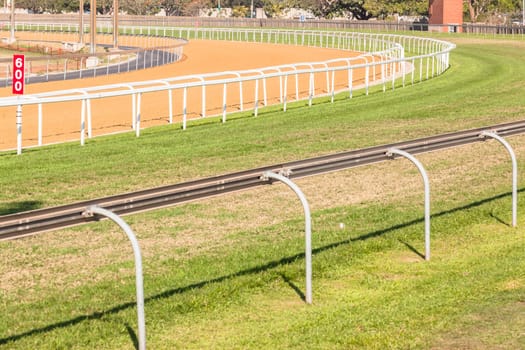 Horse racing tracks section poly synthetic and grass with railing.