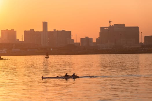 Regatta rowing crews eights quads doubles skulls on race course silhouetted on morning sunrise colors on sea waters at Durban Rowiing Club Head of the Bay Regatta July 12th 2014 Durban South-Africa