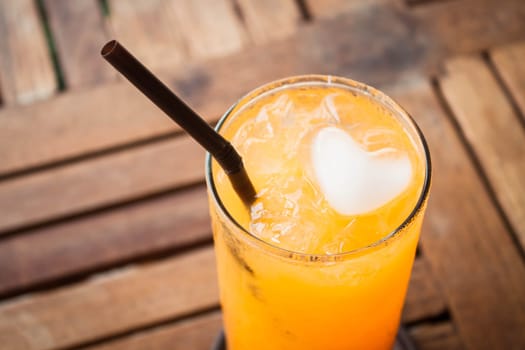 Close up orange juice with heart ice cube