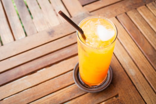 Romantic orange juice with heart ice cube