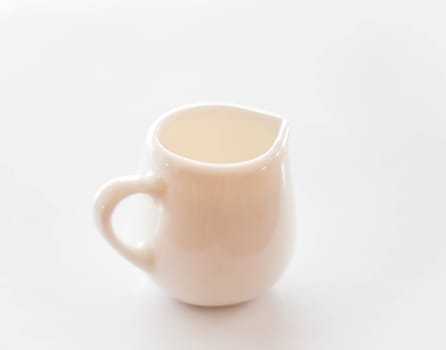 White ceramic pitcher for milk on clean table