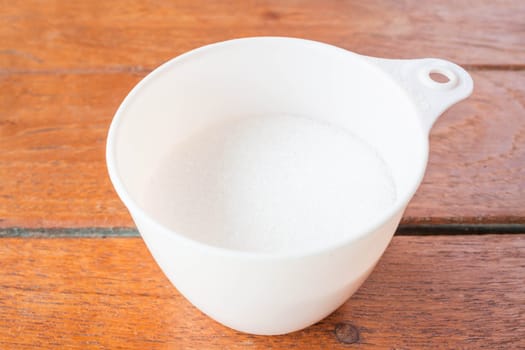 Bakery white sugar measured in plastic cup